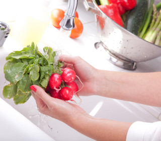 Woman Washing Radish in the Kitchen Sink.