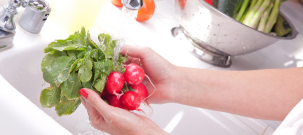 Woman Washing Radish in the Kitchen Sink.